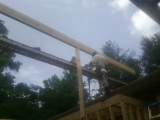 Carpenter setting a ridge beam over a new addition frame — Ice Dam Removal by Roofing Brothers in Kenilworth